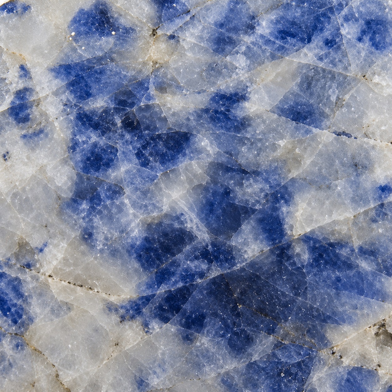 Close-up of blue sapphire material from New Zealand showing vivid blue crystalline colour and pale surrounding matrix